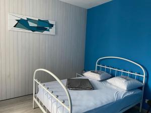 - une chambre bleue dotée d'un lit avec un mur bleu dans l'établissement Logement entier près de Mauleon.8/10 personnes, à Mauléon