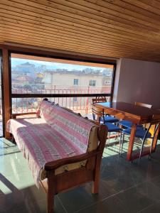 a room with a bed and a table and a window at Apartamente plazhi in Sarandë