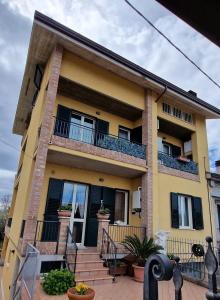 Cette maison jaune dispose d'un balcon et d'un escalier. dans l'établissement Casa di Sara, à LʼAnnunziata
