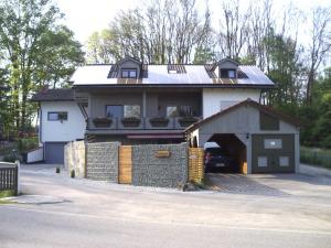 une maison avec un garage avec une voiture sous celle-ci dans l'établissement Ferienhaus Absmeier, à Bad Griesbach im Rottal
