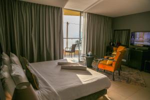 a hotel room with a bed and a living room at O Beach Hotel & Resort in Sowayma