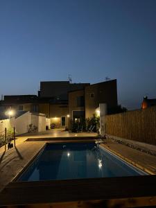 una piscina en un patio trasero por la noche en L’angolo degli aromi en Ragusa