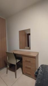 a desk with a mirror and a chair in a room at Private Room in a Big aparment in Msida