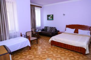 una habitación de hotel con 2 camas y una silla en SD David Hotel, en Ereván