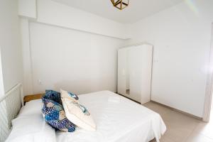 Schlafzimmer mit einem weißen Bett und einem Spiegel in der Unterkunft Ennea Suites-Light suite in Flámbouras