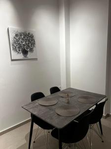 una mesa de comedor con sillas y una pintura en la pared en Ennea Suites-Light suite, en Flámbouras