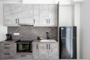 eine Küche mit einem Kühlschrank und Schränken aus Edelstahl in der Unterkunft Ennea Suites-Light suite in Flámbouras