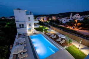 Villa con piscina por la noche en Ennea Suites-Light suite, en Flámbouras