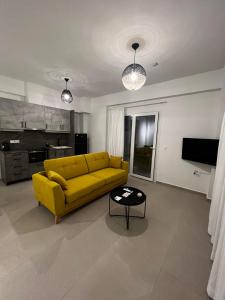 sala de estar con sofá amarillo y mesa en Ennea Suites-Light suite, en Flámbouras