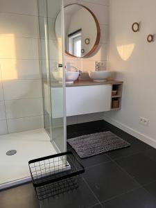 La salle de bains est pourvue de 2 lavabos et d'un miroir. dans l'établissement Ons Maashuisje, à Maaseik
