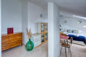 um quarto com uma cama, uma mesa e um vaso em Loft Superga on green river Po' Torino em San Mauro Torinese