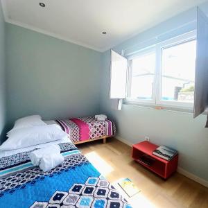 um quarto com 2 camas e uma janela em Casa do Portão Azul - Salmonete em Atouguia da Baleia
