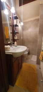 een badkamer met een wastafel, een toilet en een spiegel bij B&B SERENA in Perugia