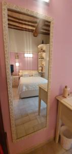 um espelho que reflecte um quarto com uma cama num quarto em B&B SERENA em Perugia