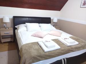 a bedroom with a bed with two towels on it at Aranka Apartman in Gyula