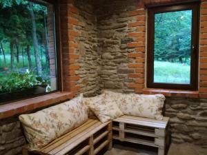 a couch sitting in a room with two windows at Niezapominajka in Kletno