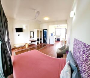 a living room with a pink couch and a kitchen at Casa Puerto Bonito & Private Coworking in Puerto Escondido