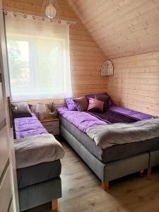 2 camas en una habitación con ventana en Lawendowe Domki i Apartamenty w Pobierowie, en Pobierowo