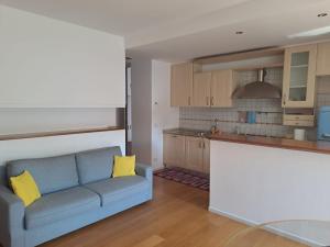 a living room with a blue couch and a kitchen at Il posto Giusto in Pieve di Soligo