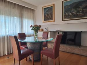 comedor con mesa, sillas y TV en Il posto Giusto, en Pieve di Soligo