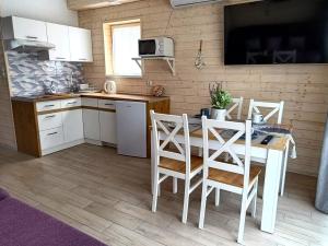 Una cocina con una mesa y sillas en una habitación. en Lawendowe Domki i Apartamenty w Pobierowie, en Pobierowo