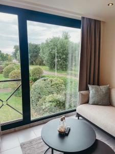 a living room with a couch and a large window at Malpertus in Bredene