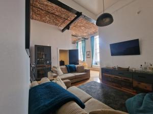 a living room with a couch and a flat screen tv at The Loft in Belfast