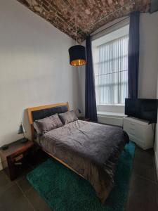 a bedroom with a bed and a large window at The Loft in Belfast