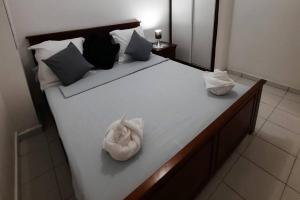 uma grande cama branca com duas toalhas em Appartement à 5 min de la plage em Bouéni