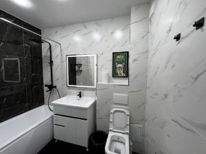 a black and white bathroom with a sink and a toilet at Entire Apartment in Central Nukus in Nukus