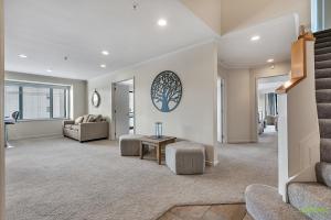 a living room with a staircase and a couch and a table at QV Stays Front Stage City Lights in Auckland