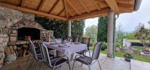 a table and chairs on a patio with a stone fireplace at Na-Vi in Novi Vinodolski