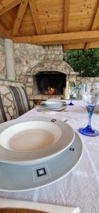 a table with wine glasses and a stone fireplace at Na-Vi in Novi Vinodolski +24 photos