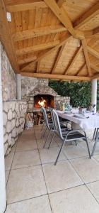 a patio with a table and chairs and a fireplace at Na-Vi in Novi Vinodolski