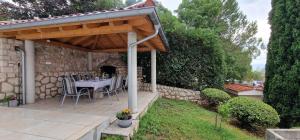 a patio with a table under a wooden pergola at Na-Vi in Novi Vinodolski