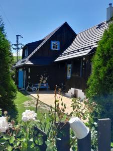 een huis met een blauw dak en een tuin met bloemen bij Drevenica Liptovsky Trnovec 166 in Liptovský Trnovec