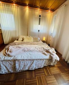 Schlafzimmer mit einem Bett mit Vorhängen und Holzboden in der Unterkunft die perfekte Auszeit in Illingen