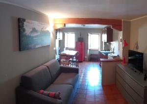 ein Wohnzimmer mit einem Sofa und einem Tisch sowie eine Küche in der Unterkunft Viottolo 12 Bike & Sky Room - Rosazza in Campiglia Cervo