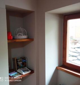 eine Ecke eines Zimmers mit einem Regal und einem Fenster in der Unterkunft Viottolo 12 Bike & Sky Room - Rosazza in Campiglia Cervo