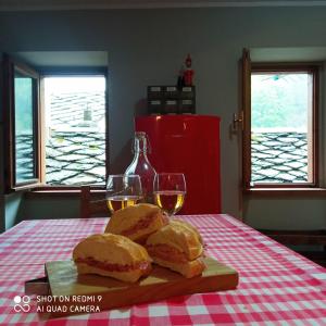 einen Tisch mit zwei Sandwiches und zwei Gläsern Wein in der Unterkunft Viottolo 12 Bike & Sky Room - Rosazza in Campiglia Cervo