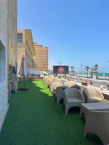 馬特魯港的住宿－Aros Al Bahr Hotel，建筑物旁边的一排椅子和遮阳伞