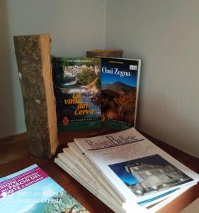 Drei Bücher liegen auf einem Tisch. in der Unterkunft Viottolo 12 Bike & Sky Room - Rosazza in Campiglia Cervo