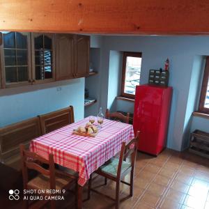 eine Küche mit einem Tisch und einem roten Kühlschrank in der Unterkunft Viottolo 12 Bike & Sky Room - Rosazza in Campiglia Cervo