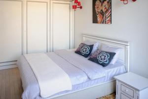 a bedroom with a white bed with pillows on it at Cozy studio, Center, Sea view in Baku