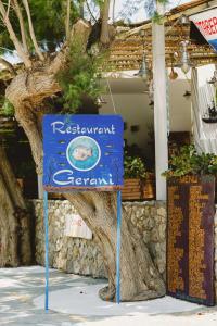 a blue sign in front of a tree at Gerani Studios in Astypalaia Town