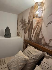 1 dormitorio con 1 cama y pared con un mural de plantas en Malo, Duplex bord de mer accès direct plage en rdc, en Dunkerque