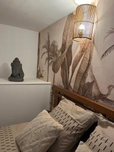 a bedroom with a bed and a wall with a plant mural at Ma cabane à la plage de Dunkerque, Duplex bord de mer accès direct plage en rdc, Malo les Bains in Dunkerque