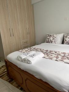 een slaapkamer met een bed met handdoeken erop bij Prime Nest Grey point 305 in Kericho