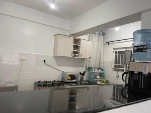 Kericho的住宿－Prime Nest Grey point 305，厨房配有白色橱柜和炉灶烤箱。