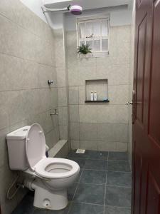 a bathroom with a white toilet and a shower at Prime Nest Grey point 305 in Kericho